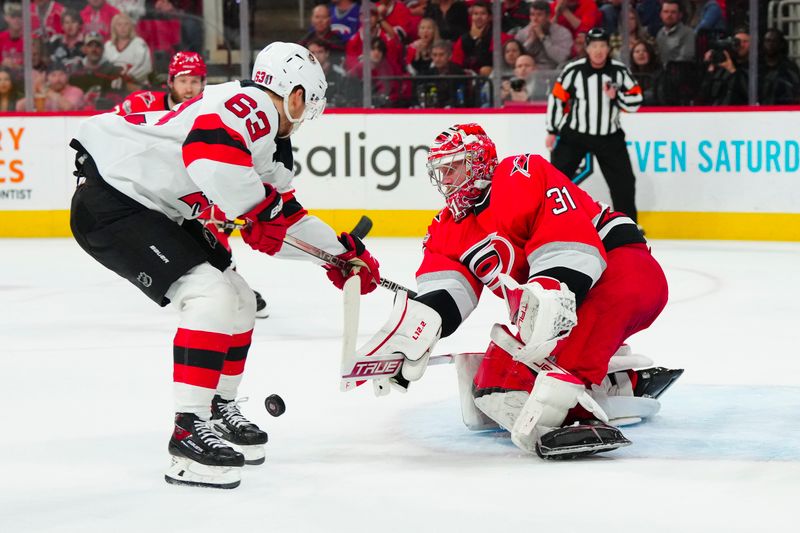 May 11, 2023; Raleigh, North Carolina, USA; Carolina Hurricanes goaltender Frederik Andersen (31) misplays the puck against New Jersey Devils left wing Jesper Bratt (63) during the second period in game five of the second round of the 2023 Stanley Cup Playoffs at PNC Arena. Mandatory Credit: James Guillory-USA TODAY Sports