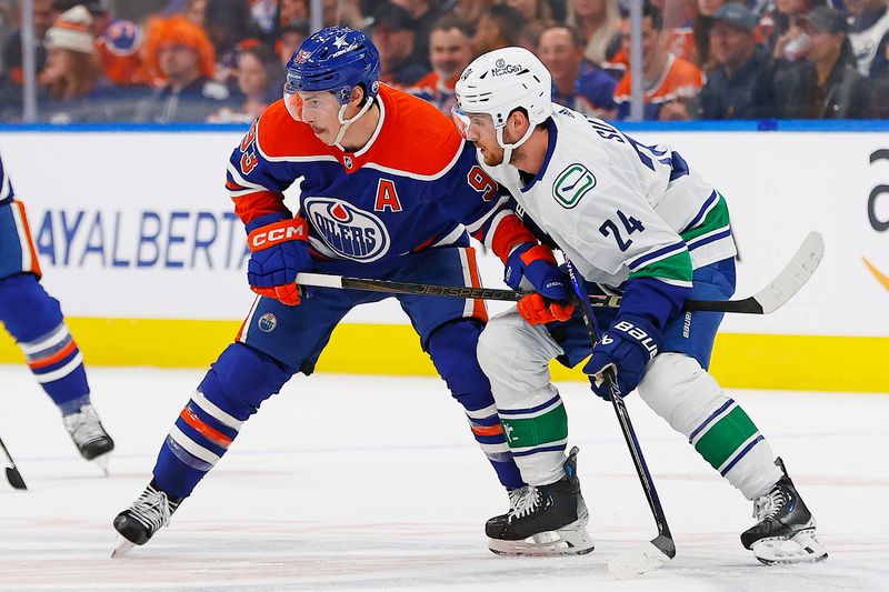 May 18, 2024; Edmonton, Alberta, CAN; Edmonton Oilers forward Ryan Nugent-Hopkins (93) and Vancouver Canucks forward Pius Suter (24) battle for position during the first period in game six of the second round of the 2024 Stanley Cup Playoffs at Rogers Place. Mandatory Credit: Perry Nelson-USA TODAY Sports