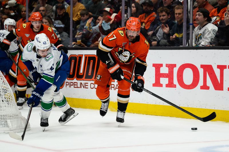 Nov 26, 2025; Anaheim, California, USA; Anaheim Ducks left wing Alex Killorn (17) controls the puck while under pressure from Vancouver Canucks defenseman Quinn Hughes (43) during the second period at Honda Center. Mandatory Credit: William Liang-Imagn Images