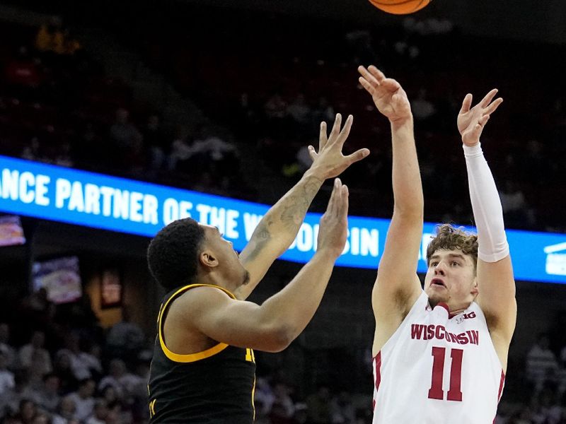 Feb 22, 2023; Madison, Wisconsin, USA; Wisconsin guard Max Klesmit (11) takes a shot over Iowa guard Tony Perkins (11) during the second half at Kohl Center. Mandatory Credit: Mark Hoffman-USA TODAY Sports