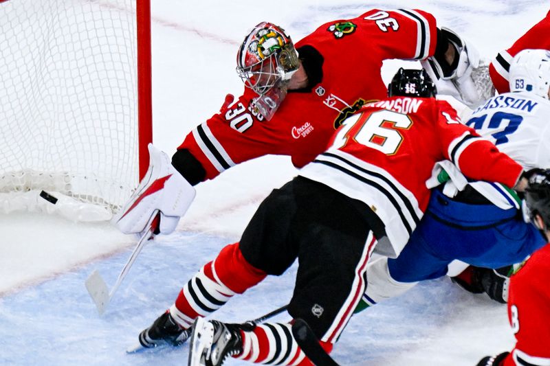 Oct 17, 2025; Chicago, Illinois, USA;  Vancouver Canucks center Max Sasson (63) scores past Chicago Blackhawks goaltender Spencer Knight (30) during the second period at the United Center. Mandatory Credit: Matt Marton-Imagn Images