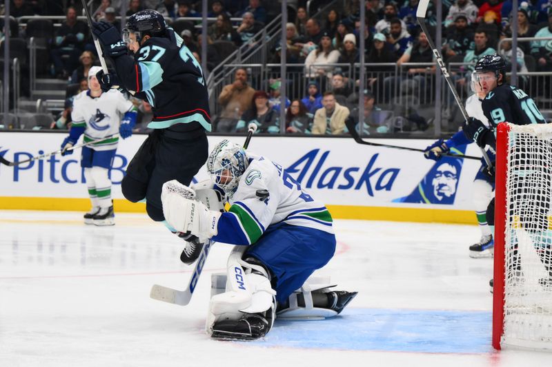 Nov 24, 2023; Seattle, Washington, USA; Vancouver Canucks goaltender Thatcher Demko (35) defects a goal shot under Seattle Kraken center Yanni Gourde (37) during the second period at Climate Pledge Arena. Mandatory Credit: Steven Bisig-USA TODAY Sports