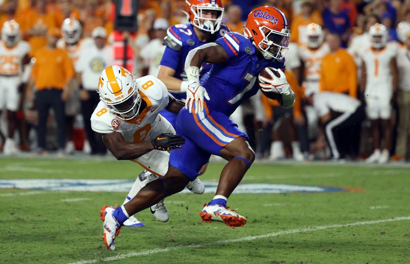 Sep 16, 2023; Gainesville, Florida, USA; Florida Gators running back Trevor Etienne (7) runs with the ball as Tennessee Volunteers defensive back Brandon Turnage (8) defends during the second quarter at Ben Hill Griffin Stadium. Mandatory Credit: Kim Klement Neitzel-USA TODAY Sports