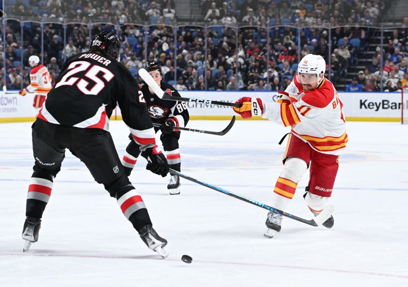 Nov 19, 2025; Buffalo, New York, USA; Calgary Flames center Mikael Backlund (11) shoots the puck past Buffalo Sabres defenseman Owen Power (25) in the first period at KeyBank Center. Mandatory Credit: Mark Konezny-Imagn Images