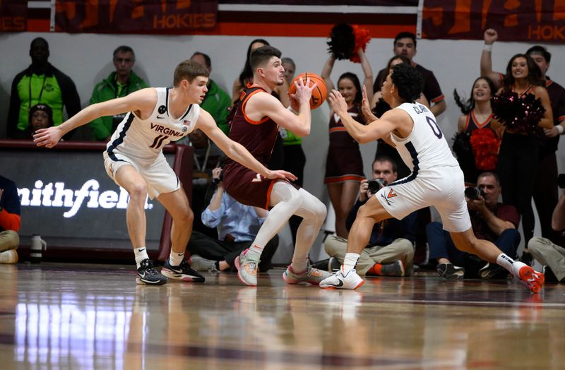 Feb 4, 2023; Blacksburg, Virginia, USA; Virginia Tech Hokies guard Hunter Cattoor (0) gets double teamed by Virginia Cavaliers guard Kihei Clark (0) and guard Isaac McKneely (11) in the second half at Cassell Coliseum. Mandatory Credit: Lee Luther Jr.-USA TODAY Sports