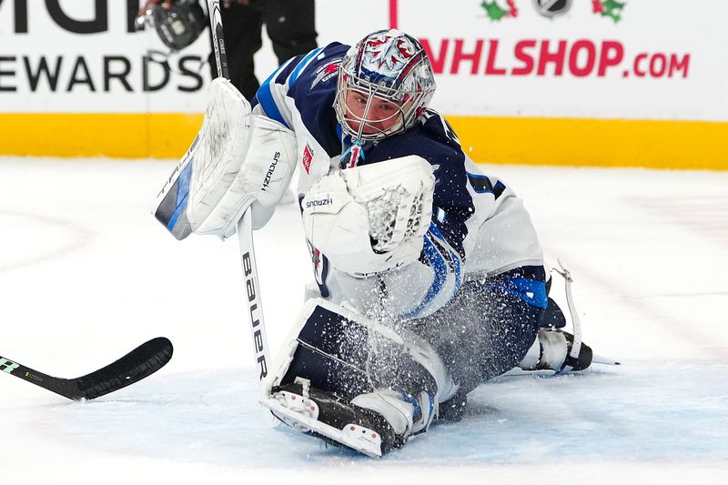 Nov 29, 2024; Las Vegas, Nevada, USA; Winnipeg Jets goaltender Eric Comrie (1) looks to make a save against the Vegas Golden Knights during the second period at T-Mobile Arena. Mandatory Credit: Stephen R. Sylvanie-Imagn Images