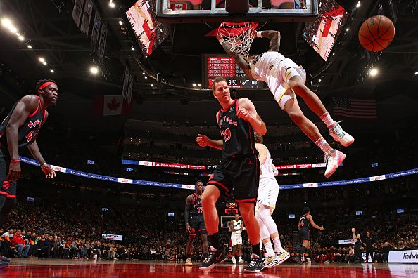 TORONTO, CANADA - DECEMBER 23:  John Collins #20 of the Utah Jazz dunks the ball over Jakob Poeltl #19 of the Toronto Raptors during the game against the Toronto Raptors on December 23, 2023 at the Scotiabank Arena in Toronto, Ontario, Canada.  NOTE TO USER: User expressly acknowledges and agrees that, by downloading and or using this Photograph, user is consenting to the terms and conditions of the Getty Images License Agreement.  Mandatory Copyright Notice: Copyright 2023 NBAE (Photo by Vaughn Ridley/NBAE via Getty Images)