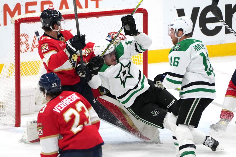 Dec 6, 2023; Sunrise, Florida, USA; Dallas Stars center Roope Hintz (24) falls down in the crease as Florida Panthers defenseman Brandon Montour (62) defends during the second period at Amerant Bank Arena. Mandatory Credit: Jim Rassol-USA TODAY Sports