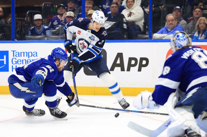 Jan 29, 2026; Tampa, Florida, USA; Winnipeg Jets center Morgan Barron (36) skates with the puck as Tampa Bay Lightning defenseman Erik Cernak (81) and goaltender Andrei Vasilevskiy (88) defend during the second period at Benchmark International Arena. Mandatory Credit: Kim Klement Neitzel-Imagn Images