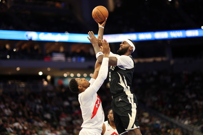 MILWAUKEE, WISCONSIN - NOVEMBER 12: Bobby Portis #9 of the Milwaukee Bucks shoots over RJ Barrett #9 of the Toronto Raptors during the second half of a game in the NBA Emirates Cup at Fiserv Forum on November 12, 2024 in Milwaukee, Wisconsin. NOTE TO USER: User expressly acknowledges and agrees that, by downloading and or using this photograph, User is consenting to the terms and conditions of the Getty Images License Agreement. (Photo by Stacy Revere/Getty Images)