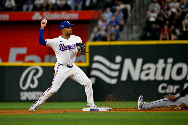 Apr 23, 2024; Arlington, Texas, USA; Texas Rangers second baseman Marcus Semien (2) turns a double play against the Seattle Mariners at Globe Life Field. Mandatory Credit: Jerome Miron-USA TODAY Sports