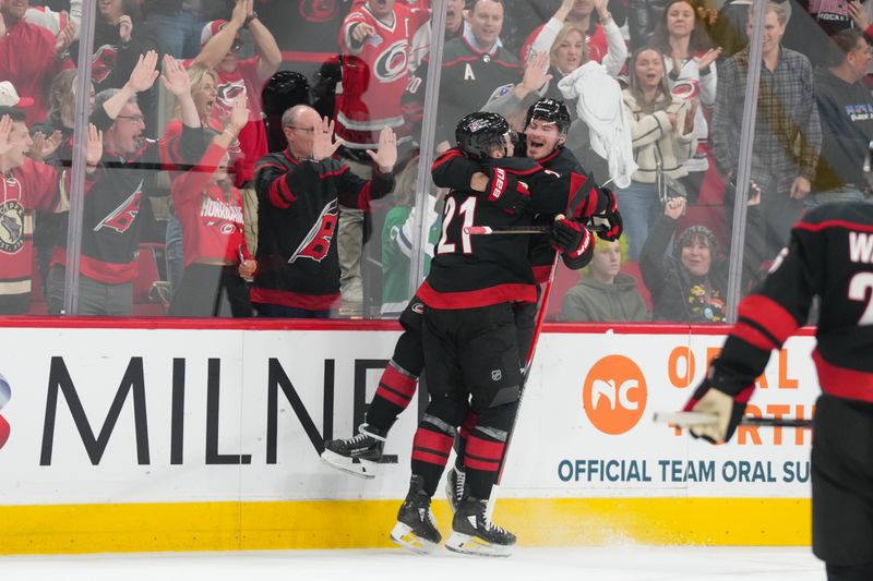 Nov 6, 2025; Raleigh, North Carolina, USA;  Carolina Hurricanes right wing Andrei Svechnikov (37) celebrates his goal with defenseman Alexander Nikishin (21) against the Minnesota Wild during the first period at Lenovo Center. Mandatory Credit: James Guillory-Imagn Images
