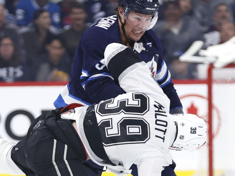 Oct 11, 2025; Winnipeg, Manitoba, CAN; Winnipeg Jets defenseman Luke Schenn (5) and Los Angeles Kings left wing Jeff Malott (39) fight in the first period at Canada Life Centre. Mandatory Credit: James Carey Lauder-Imagn Images