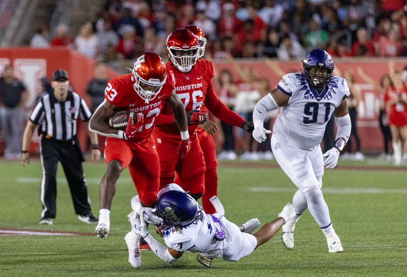 Sep 16, 2023; Houston, Texas, USA; Houston Cougars running back Parker Jenkins (23) breaks the tackle of TCU Horned Frogs cornerback Channing Canada (7) in the first half at TDECU Stadium. Mandatory Credit: Thomas Shea-USA TODAY Sports