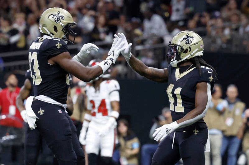 New Orleans Saints running back Alvin Kamara, right, is congratulated by tight end Juwan Johnson after scoring against the Tampa Bay Buccaneers during the first half of an NFL football game in New Orleans, Sunday, Oct. 13, 2024. (AP Photo/Butch Dill)