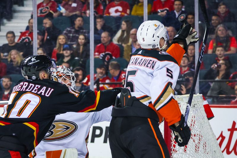 Apr 2, 2024; Calgary, Alberta, CAN; Anaheim Ducks defenseman Urho Vaakanainen (5) reaches for the puck during the third period against the Calgary Flames at Scotiabank Saddledome. Mandatory Credit: Sergei Belski-USA TODAY Sports