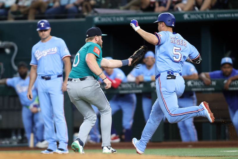 Jun 29, 2025; Arlington, Texas, USA; Seattle Mariners first baseman Luke Raley (20) tags out Texas Rangers shortstop Corey Seager (5) at first base during the first inning at Globe Life Field. Mandatory Credit: Tim Heitman-Imagn Images