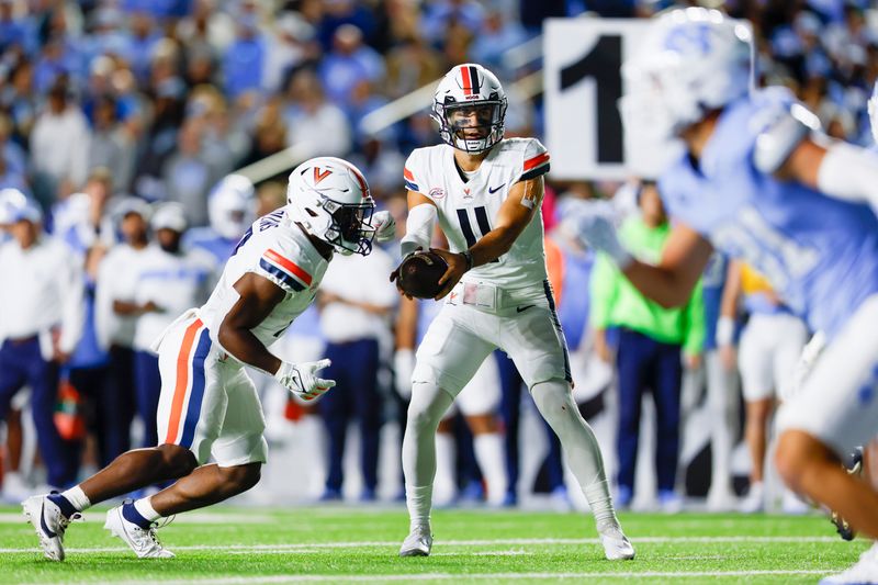 Oct 21, 2023; Chapel Hill, North Carolina, USA; Virginia Cavaliers quarterback Tony Muskett (11) hands off to running back Mike Hollins (7) in the first half against the North Carolina Tar Heels at Kenan Memorial Stadium. Mandatory Credit: Nell Redmond-USA TODAY Sports