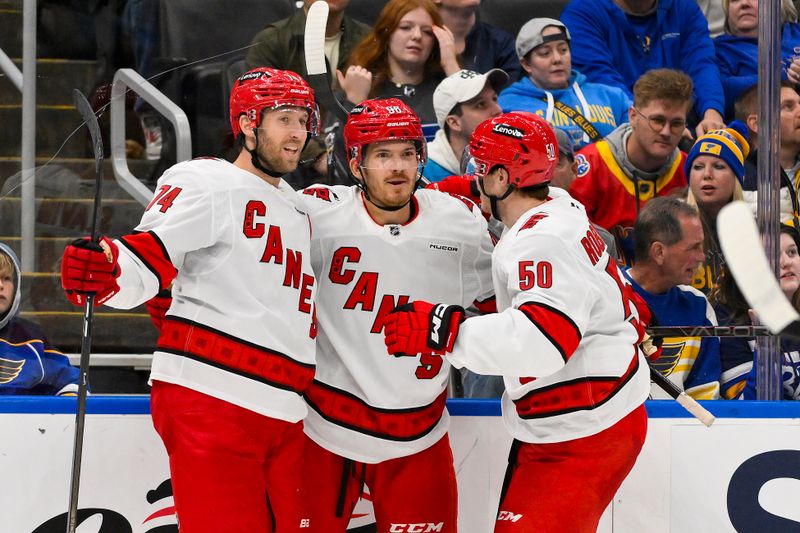 Oct 19, 2024; St. Louis, Missouri, USA;  Carolina Hurricanes center Jack Roslovic (96) is congratulated by defenseman Jaccob Slavin (74) and left wing Eric Robinson (50) after scoring against the St. Louis Blues during the third period at Enterprise Center. Mandatory Credit: Jeff Curry-Imagn Images