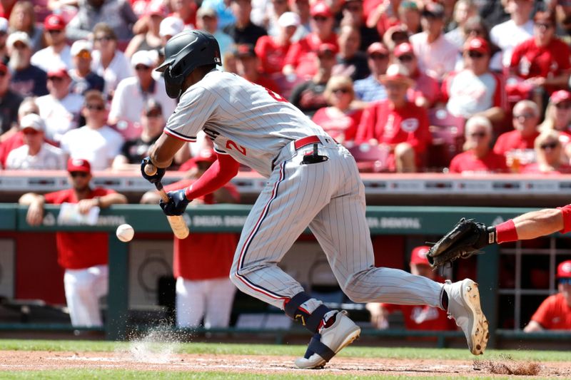 Sep 20, 2023; Cincinnati, Ohio, USA; Minnesota Twins center fielder Michael A. Taylor (2) hits a sacrifice bunt against the Cincinnati Reds during the third inning at Great American Ball Park. Mandatory Credit: David Kohl-USA TODAY Sports