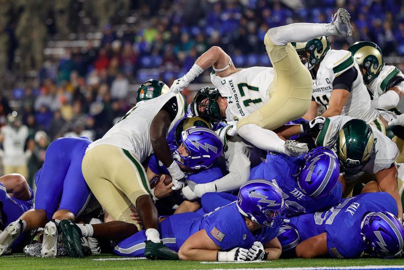 Oct 19, 2024; Colorado Springs, Colorado, USA; Air Force Falcons quarterback John Busha (3) holds onto the ball as he is surrounded by Colorado State Rams linebacker Buom Jock (8) and defensive back Jack Howell (17) on a play in the fourth quarter at Falcon Stadium. Mandatory Credit: Isaiah J. Downing-Imagn Images