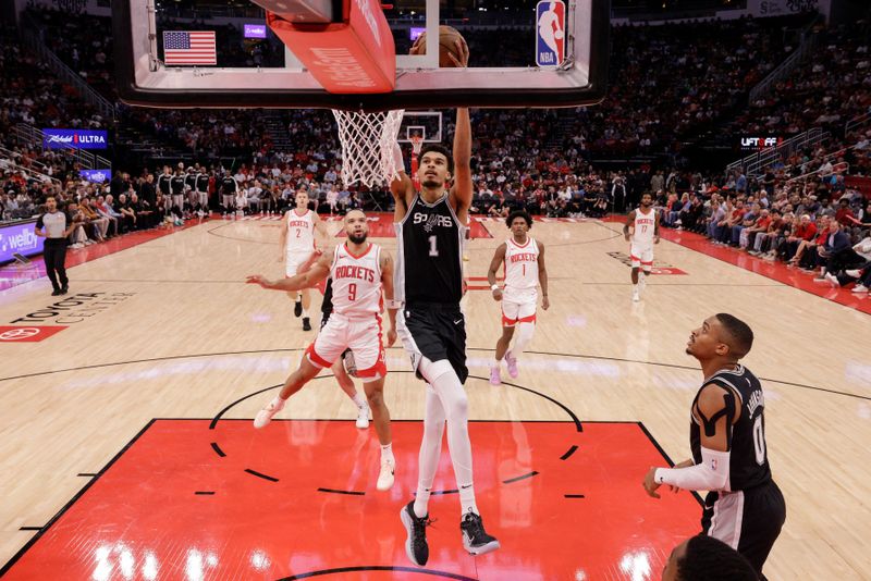 HOUSTON, TEXAS - NOVEMBER 06: Victor Wembanyama #1 of the San Antonio Spurs goes up for a dunk in front of Dillon Brooks #9 of the Houston Rockets in the first half at Toyota Center on November 06, 2024 in Houston, Texas.  NOTE TO USER: User expressly acknowledges and agrees that, by downloading and or using this photograph, User is consenting to the terms and conditions of the Getty Images License Agreement.  (Photo by Tim Warner/Getty Images)