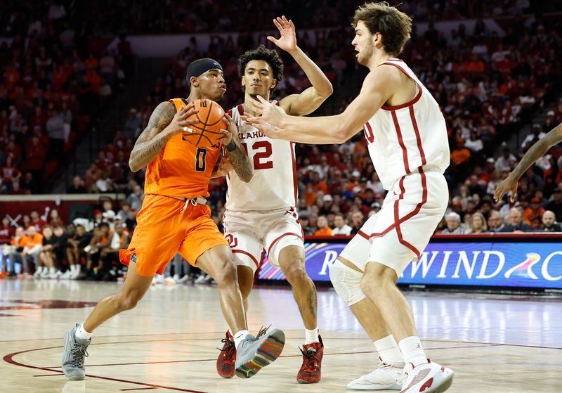 Feb 1, 2023; Norman, Oklahoma, USA; Oklahoma State Cowboys guard Avery Anderson III (0) moves to the basket against Oklahoma Sooners guard Milos Uzan (12) and forward Sam Godwin (10) during the first half at Lloyd Noble Center. Mandatory Credit: Alonzo Adams-USA TODAY Sports