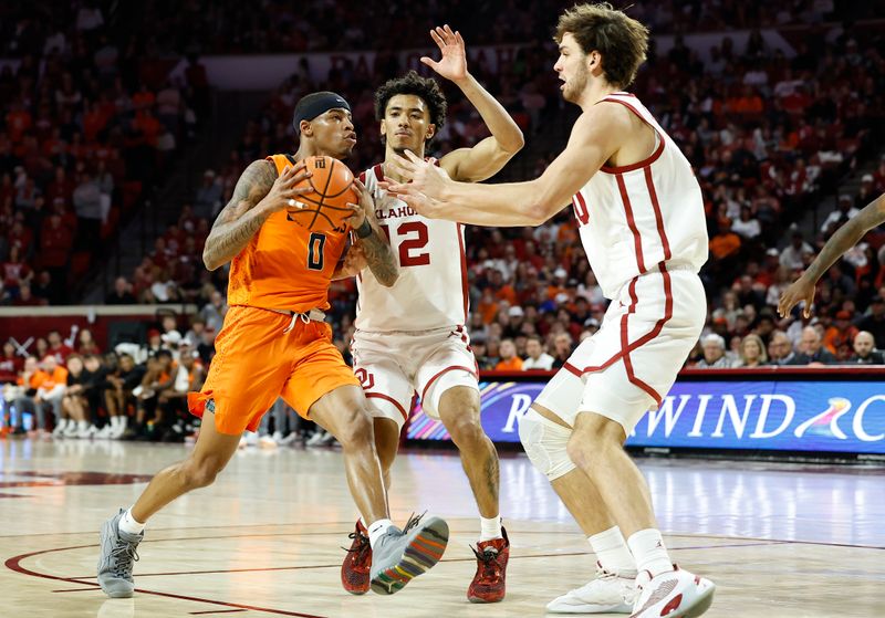 Feb 1, 2023; Norman, Oklahoma, USA; Oklahoma State Cowboys guard Avery Anderson III (0) moves to the basket against Oklahoma Sooners guard Milos Uzan (12) and forward Sam Godwin (10) during the first half at Lloyd Noble Center. Mandatory Credit: Alonzo Adams-USA TODAY Sports