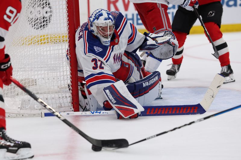 Mar 7, 2026; Newark, New Jersey, USA; New York Rangers goaltender Jonathan Quick (32) tracks the puck off the stick of New Jersey Devils center Dawson Mercer (91) during the second period at Prudential Center. Mandatory Credit: Thomas Salus-Imagn Images