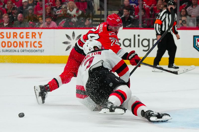 May 11, 2023; Raleigh, North Carolina, USA; New Jersey Devils defenseman Dougie Hamilton (7) stops Carolina Hurricanes center Seth Jarvis (24) scoring attempt during the third period in game five of the second round of the 2023 Stanley Cup Playoffs at PNC Arena. Mandatory Credit: James Guillory-USA TODAY Sports