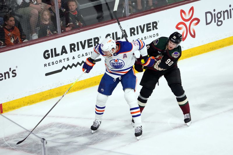 Feb 19, 2024; Tempe, Arizona, USA; Edmonton Oilers center Leon Draisaitl (29) shields of Arizona Coyotes defenseman J.J. Moser (90) during the first period at Mullett Arena. Mandatory Credit: Joe Camporeale-USA TODAY Sports