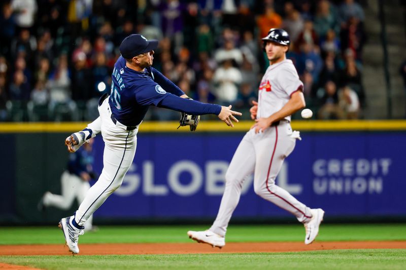 Apr 30, 2024; Seattle, Washington, USA; Seattle Mariners shortstop Dylan Moore (25) throws to first base for the final out of the top of the eighth inning against the Atlanta Braves at T-Mobile Park. Mandatory Credit: Joe Nicholson-USA TODAY Sports