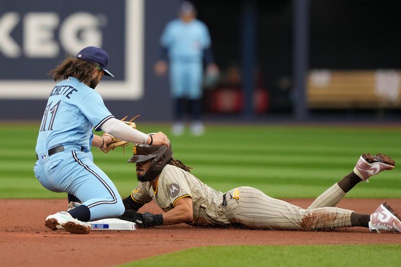 Jul 18, 2023; Toronto, Ontario, CAN; San Diego Padres right fielder Fernando Tatis Jr. (23) steals second base against Toronto Blue Jays shortstop Bo Bichette (11) during the first inning at Rogers Centre. Mandatory Credit: John E. Sokolowski-USA TODAY Sports