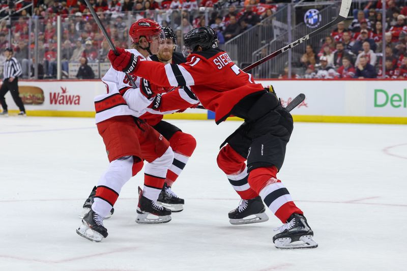 Apr 27, 2025; Newark, New Jersey, USA; New Jersey Devils defenseman Jonas Siegenthaler (71) hits Carolina Hurricanes right wing Jackson Blake (53) during the first period in game four of the first round of the 2025 Stanley Cup Playoffs at Prudential Center. Mandatory Credit: Ed Mulholland-Imagn Images