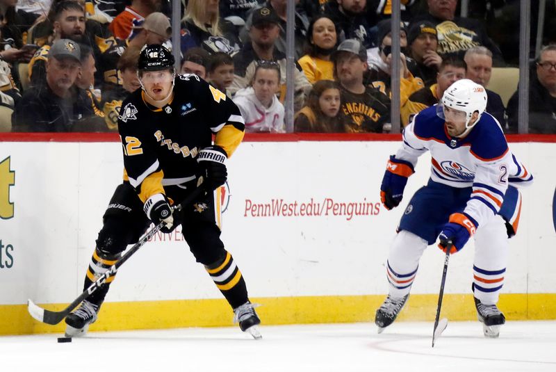 Feb 23, 2023; Pittsburgh, Pennsylvania, USA; Pittsburgh Penguins right wing Kasperi Kapanen (42) moves the puck against Edmonton Oilers defenseman Evan Bouchard (2) during the third period at PPG Paints Arena. Edmonton won 7-2. Mandatory Credit: Charles LeClaire-USA TODAY Sports