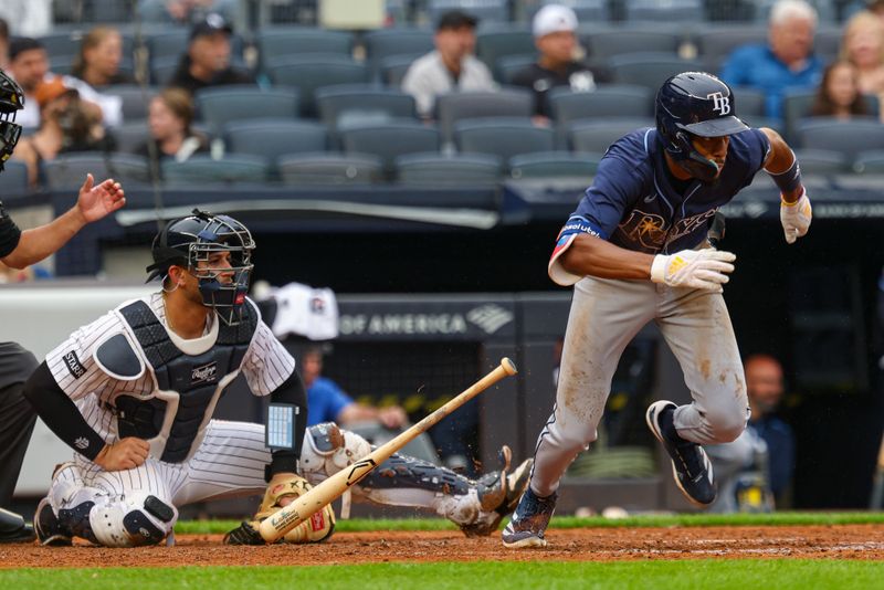 May 4, 2025; Bronx, New York, USA; Tampa Bay Rays center fielder Chandler Simpson (14) hits an infield single during the fifth inning against the New York Yankees at Yankee Stadium. Mandatory Credit: Vincent Carchietta-Imagn Images