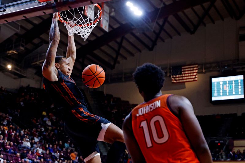 Jan 4, 2025; Blacksburg, Virginia, USA; Miami Hurricanes guard Matthew Cleveland (0) dunks the ball against Virginia Tech Hokies guard Tyler Johnson (10) during the second half at Cassell Coliseum. Mandatory Credit: Peter Casey-Imagn Images