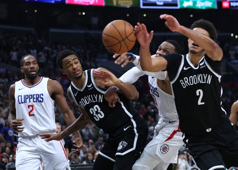 LOS ANGELES, CALIFORNIA - JANUARY 21: Russell Westbrook #0 of the LA Clippers and goes for a rebound between Cameron Johnson #2 and Nic Claxton #33 of the Brooklyn Nets as Kawhi Leonard #2 looks on during a 125-114 Clippers win at Crypto.com Arena on January 21, 2024 in Los Angeles, California. User is consenting to the terms and conditions of the Getty Images License Agreement. (Photo by Harry How/Getty Images)