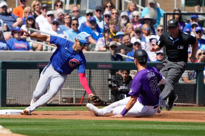 Mar 21, 2024; Salt River Pima-Maricopa, Arizona, USA; Chicago Cubs third baseman Christopher Morel (5) tags out Colorado Rockies right fielder Nolan Jones (22) on a pick off play in the second inning at Salt River Fields at Talking Stick. Mandatory Credit: Rick Scuteri-USA TODAY Sports