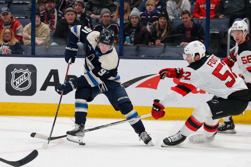 Jan 19, 2024; Columbus, Ohio, USA; New Jersey Devils defenseman Cal Foote (52) plays for the puck against Columbus Blue Jackets left wing Kent Johnson (91) during the first period at Nationwide Arena. Mandatory Credit: Russell LaBounty-USA TODAY Sports