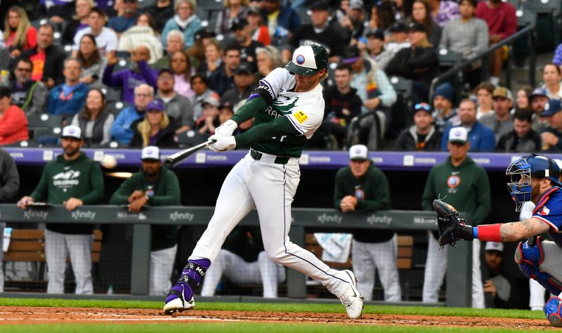 May 11, 2024; Denver, Colorado, USA; Colorado Rockies third base Ryan McMahon (24) hits a single against the Texas Rangers in the third inning at Coors Field. Mandatory Credit: John Leyba-USA TODAY Sports