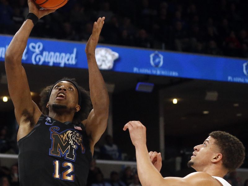 Jan 26, 2023; Memphis, Tennessee, USA; Memphis Tigers forward DeAndre Williams (12) drives to the basket as Southern Methodist Mustangs forward Samuell Williamson  (11) defends during the first half at FedExForum. Mandatory Credit: Petre Thomas-USA TODAY Sports