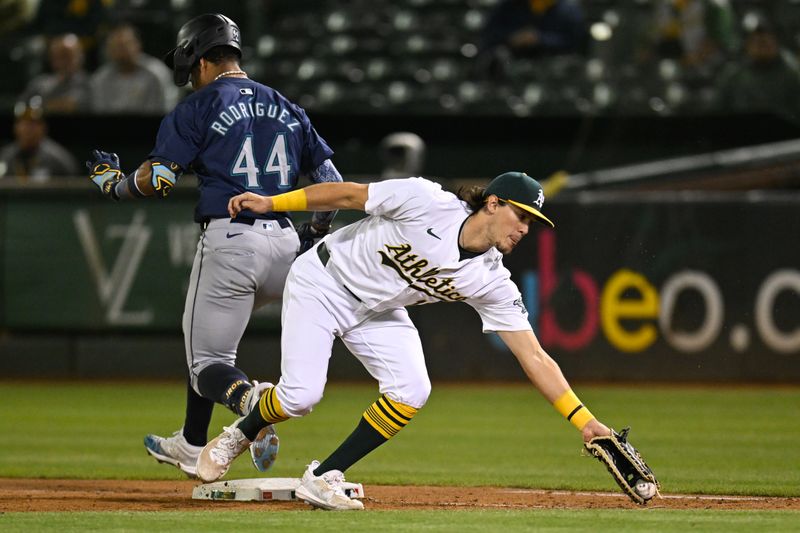 Sep 4, 2024; Oakland, California, USA; Seattle Mariners outfielder Julio Rodríguez (44) makes it safely to first base against Oakland Athletics first baseman Tristan Gray (16) in the seventh inning at Oakland-Alameda County Coliseum. Mandatory Credit: Eakin Howard-Imagn Images