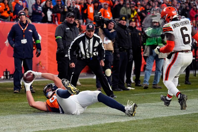 Denver Broncos tight end Adam Trautman stays in bounds while catching a touchdown pass as Cleveland Browns linebacker Jeremiah Owusu-Koramoah (6) watches during the second half of an NFL football game on Sunday, Nov. 26, 2023, in Denver. (AP Photo/Jack Dempsey)