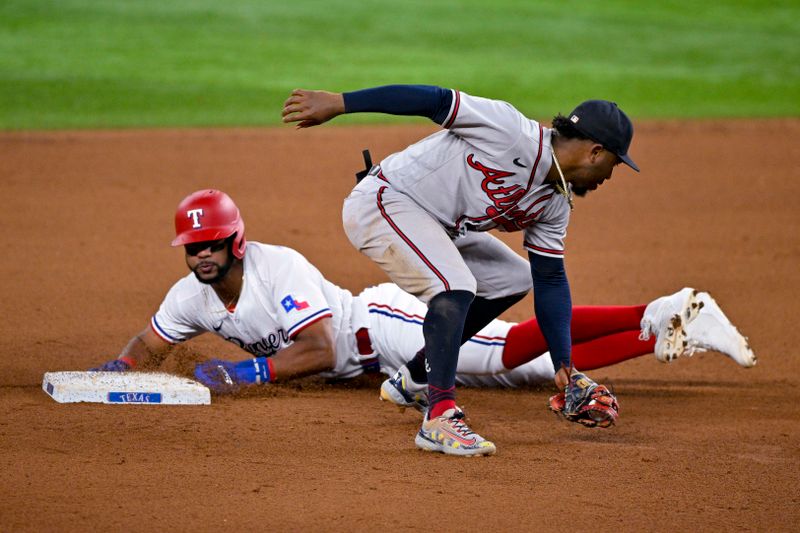 May 16, 2023; Arlington, Texas, USA; Texas Rangers center fielder Leody Taveras (3) steals second base past Atlanta Braves second baseman Ozzie Albies (1) during the seventh inning at Globe Life Field. Mandatory Credit: Jerome Miron-USA TODAY Sports