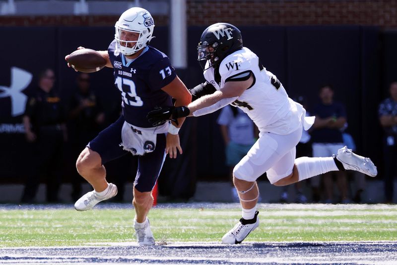 Sep 16, 2023; Norfolk, Virginia, USA; Old Dominion Monarchs quarterback Grant Wilson (13) runs the ball against Wake Forest Demon Deacons linebacker Zach Ranson (34) during the first quarter at Kornblau Field at S.B. Ballard Stadium. Mandatory Credit: Peter Casey-USA TODAY Sports