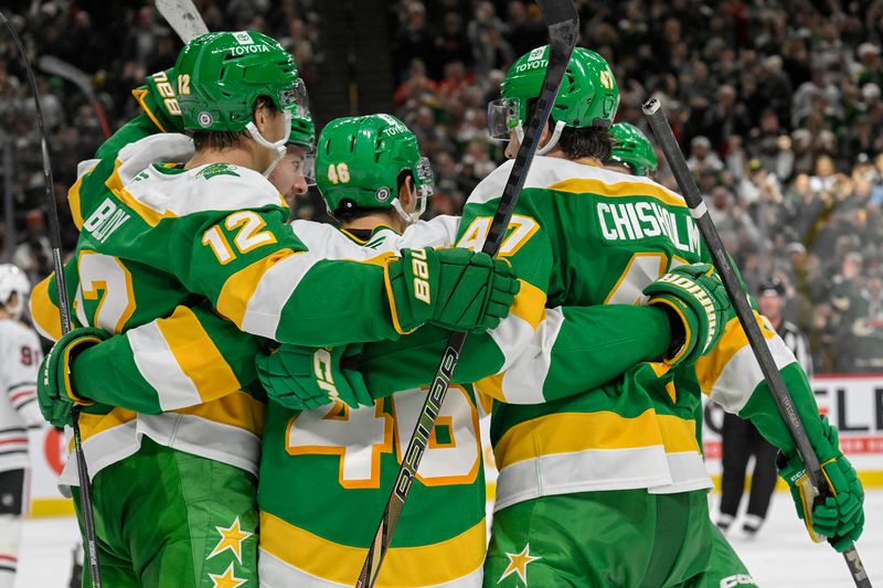 Nov 29, 2024; Saint Paul, Minnesota, USA;  Minnesota Wild defenseman Jared Spurgeon (46) celebrates his goal against the Chicago Blackhawks with forward Matt Boldy (12) and defenseman Declan Chisholm (47) during the second period at Xcel Energy Center. Mandatory Credit: Nick Wosika-Imagn Images