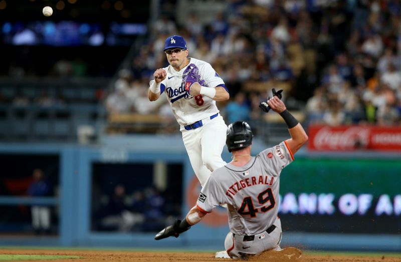Jul 23, 2024; Los Angeles, California, USA; Los Angeles Dodgers third baseman Enrique Hernandez (8) tuns a double play during the seventh inning against the San Francisco Giants at Dodger Stadium. Mandatory Credit: Jason Parkhurst-USA TODAY Sports