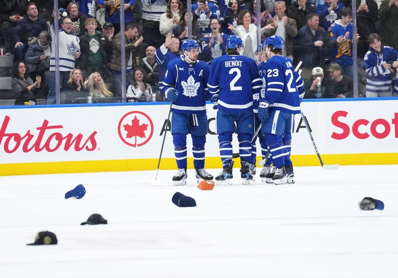 Feb 17, 2024; Toronto, Ontario, CAN; Toronto Maple Leafs center Auston Matthews (34) scores his third goal and celebrates with defenseman Simon Benoit (2) against the Anaheim Ducks during the second period at Scotiabank Arena. Mandatory Credit: Nick Turchiaro-USA TODAY Sports