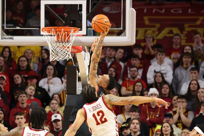 Feb 17, 2024; Ames, Iowa, USA; Texas Tech Red Raiders guard KyeRon Lindsay (21) scores against Iowa State Cyclones forward Robert Jones (12) during the first half at James H. Hilton Coliseum. Mandatory Credit: Reese Strickland-USA TODAY Sports